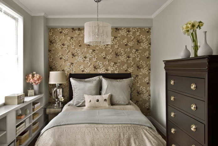 Una de las paredes está cubierta con papel pintado con un estampado floral.