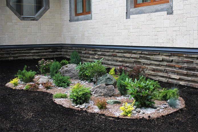 jardinera con piedras cerca de la casa