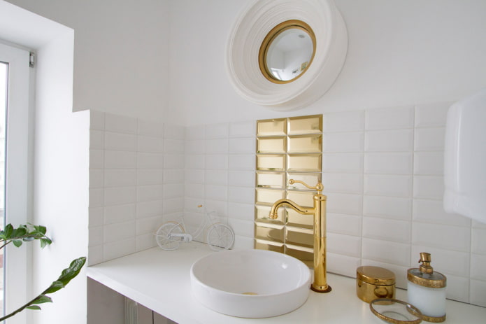 Azulejos blancos y dorados en el interior del baño
