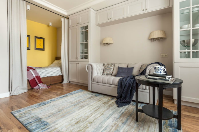 Cama tras cortinas y sofá en arco