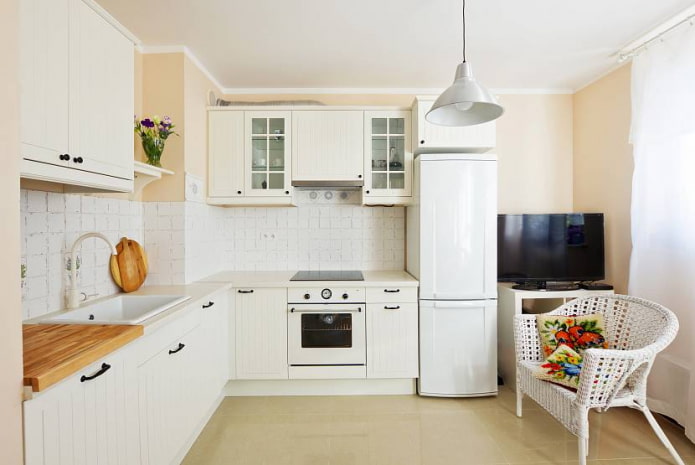 Cocina blanca en forma de L con un conducto en la esquina