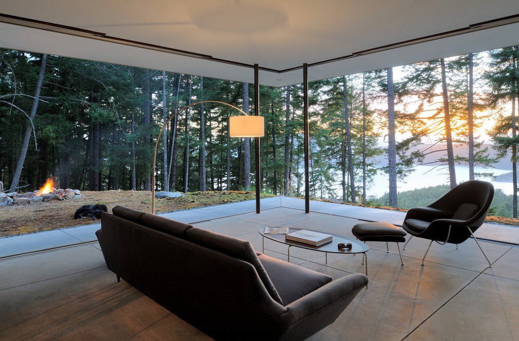 Interior de un salón en una casa de campo con ventanas panorámicas