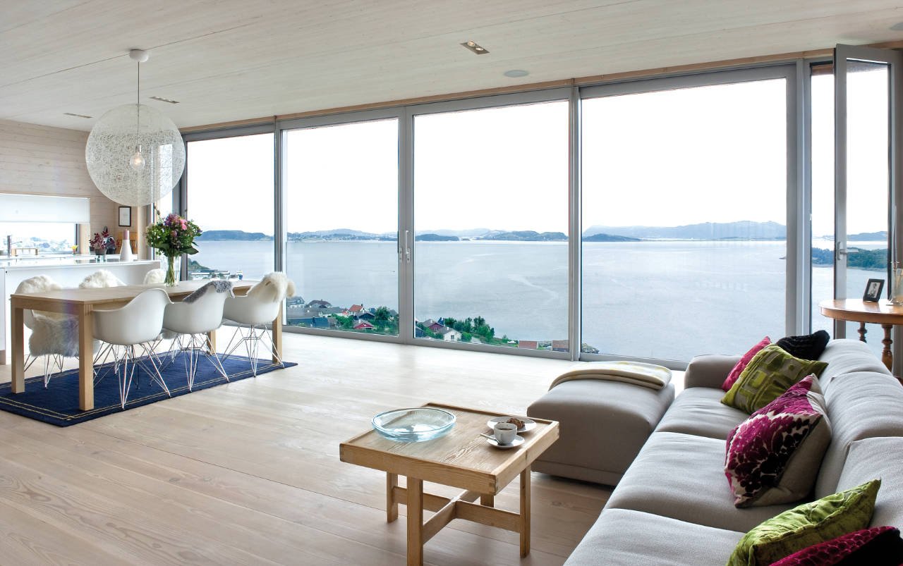 Interior de un salón en una casa de campo con ventanas panorámicas