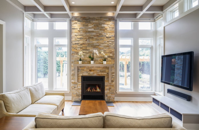 Chimenea y televisor en el interior del salón de una casa de campo