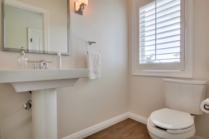 interior de un pequeño baño moderno con paredes pintadas de tonos claros