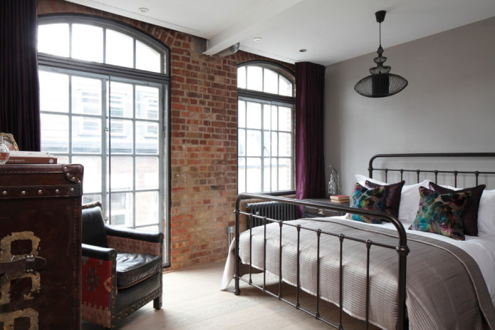 cama de hierro forjado en un dormitorio tipo loft