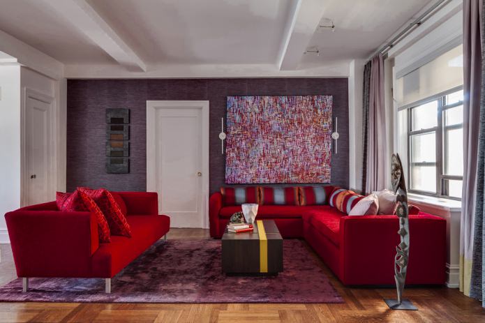 Papel pintado morado y sofá de tela rojo