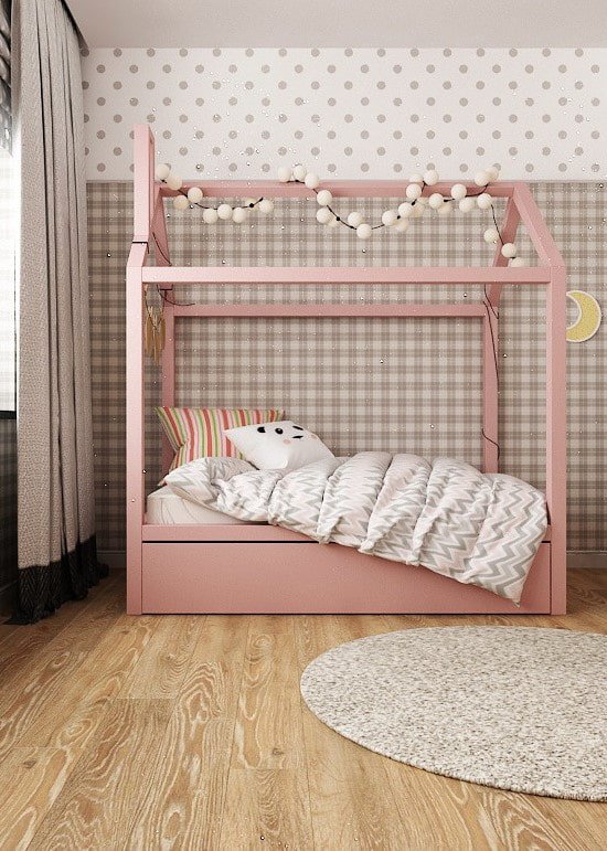 Cama rosa con forma de casa en una habitación infantil