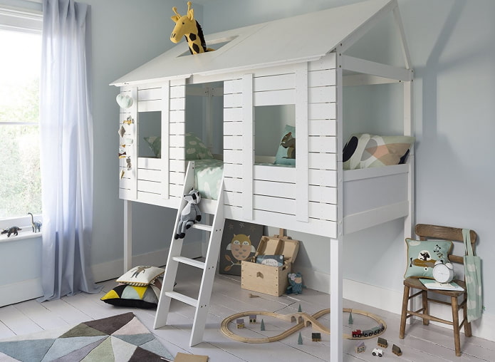 cama con forma de casa y zona de juegos en la habitación del bebé