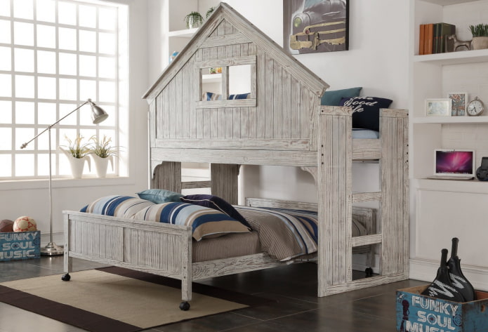 Cama gris con forma de casa en una habitación infantil