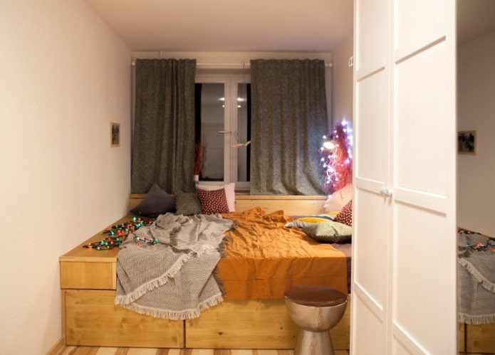 cama en un podio en una habitación pequeña