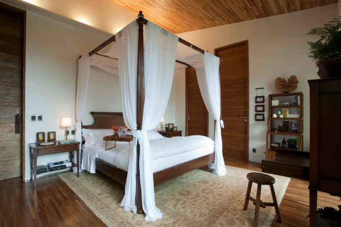 cama de madera con dosel en el interior