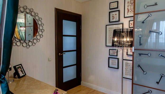 combinación de papel pintado claro con una puerta marrón oscuro con inserciones de vidrio