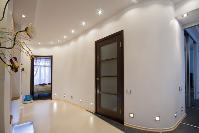 Combinación de paredes claras con una puerta marrón oscuro con inserciones de vidrio