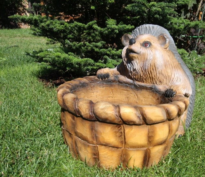 escultura de un erizo con una cesta de madera quemada