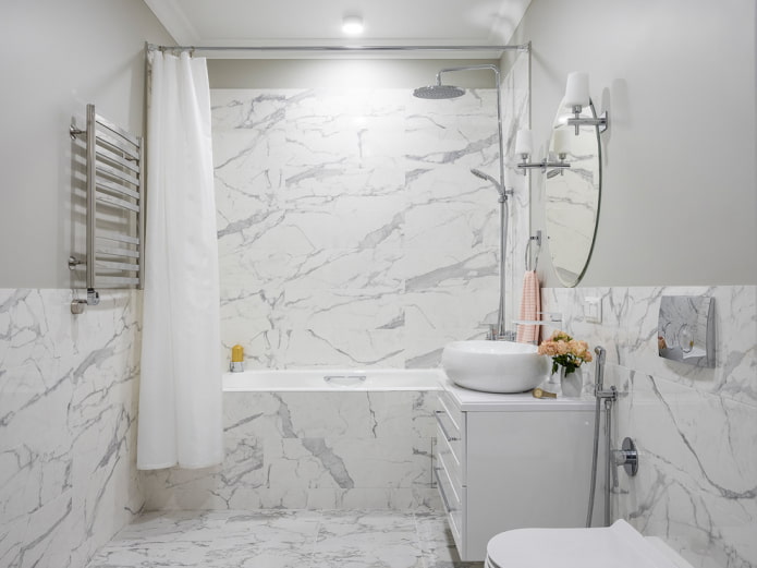 Azulejos de mármol en media pared y en la ducha
