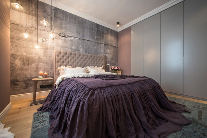 Cama con colcha morada en el dormitorio