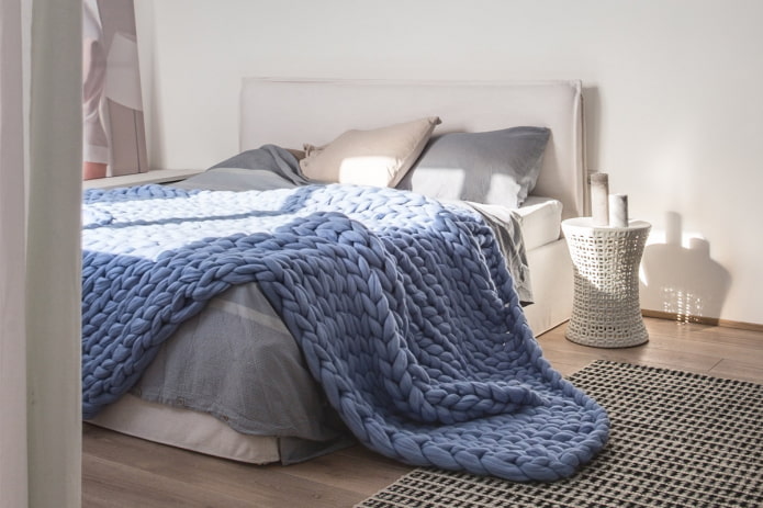cama con una gran colcha de punto en el dormitorio