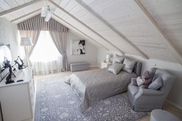 Cama con colcha gris en el dormitorio