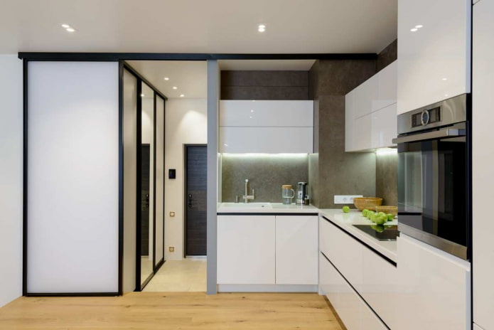 Cocina pequeña con paredes grises, suelo de madera clara y muebles blancos
