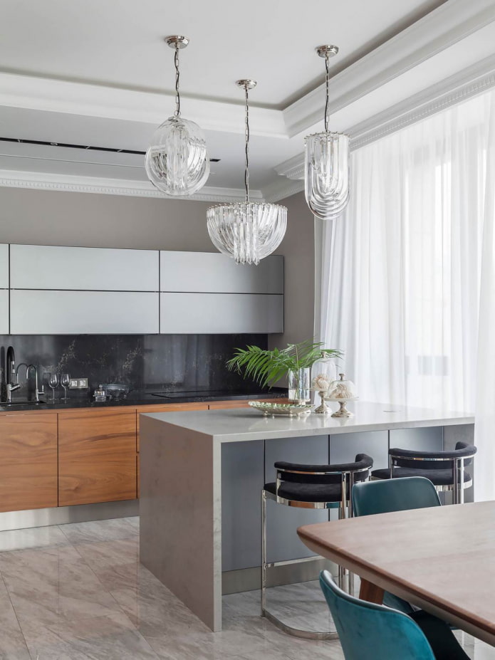 Armarios de madera, lámparas originales y sillas turquesa en una cocina gris y blanca