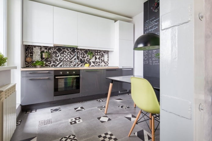 cocina gris y blanca con mosaicos en el suelo y en el delantal