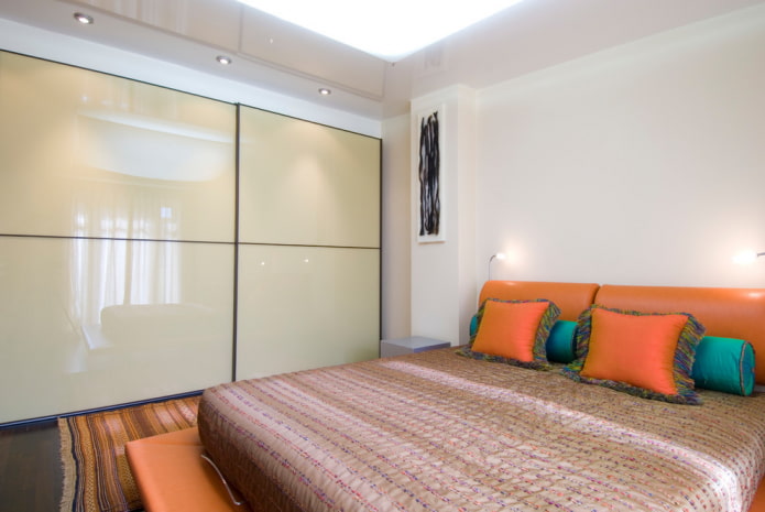 Armario corredero con fachada brillante en el interior del dormitorio