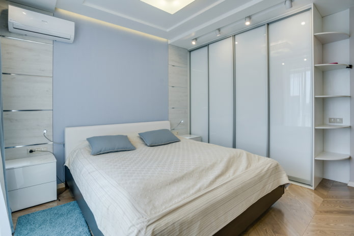 Armario blanco con puertas correderas en el interior de un dormitorio