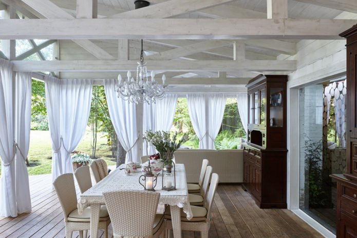 cortinas blancas con ojales en la terraza de una casa de campo