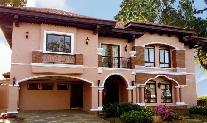 casa rosa melocotón con techo burdeos