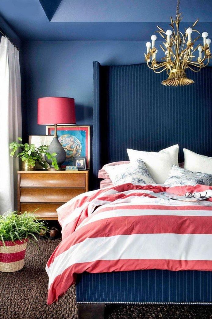un dormitorio azul con detalles en rojo