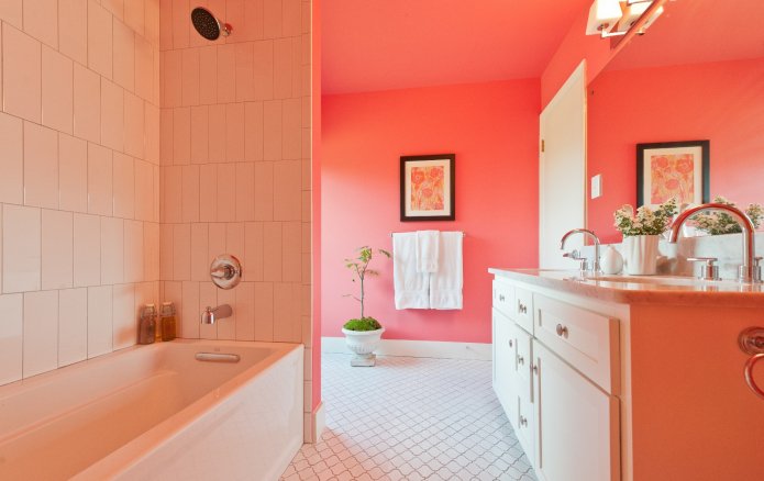 paredes pintadas de coral y azulejos blancos en el baño