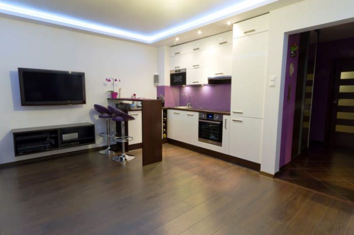 Diseño de cocina-salón con barra de bar en tonos blancos y morados