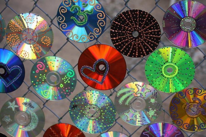 discos compactos sobre una cerca de alambre