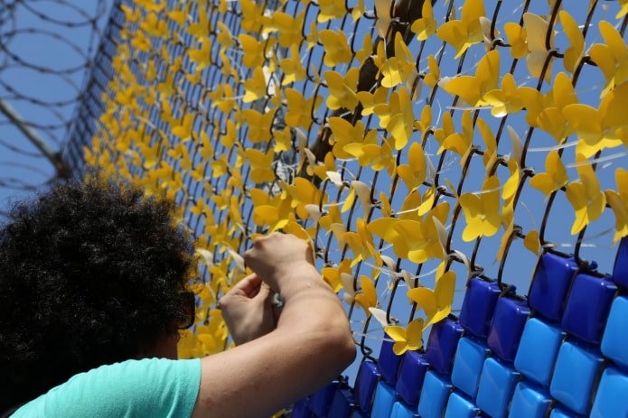 Mujer decorando una cerca de alambre
