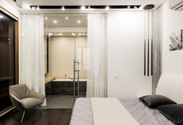 baño-dormitorio con mampara de cristal y cortina