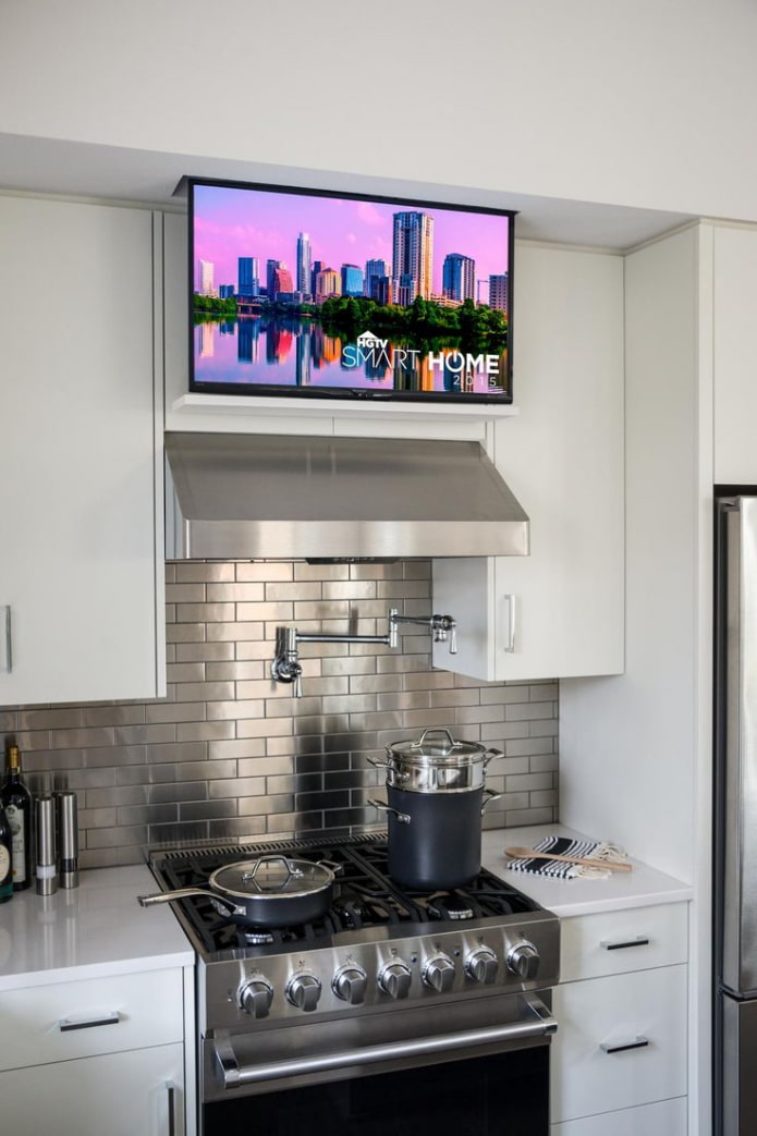 Televisor sobre la campana extractora en la cocina