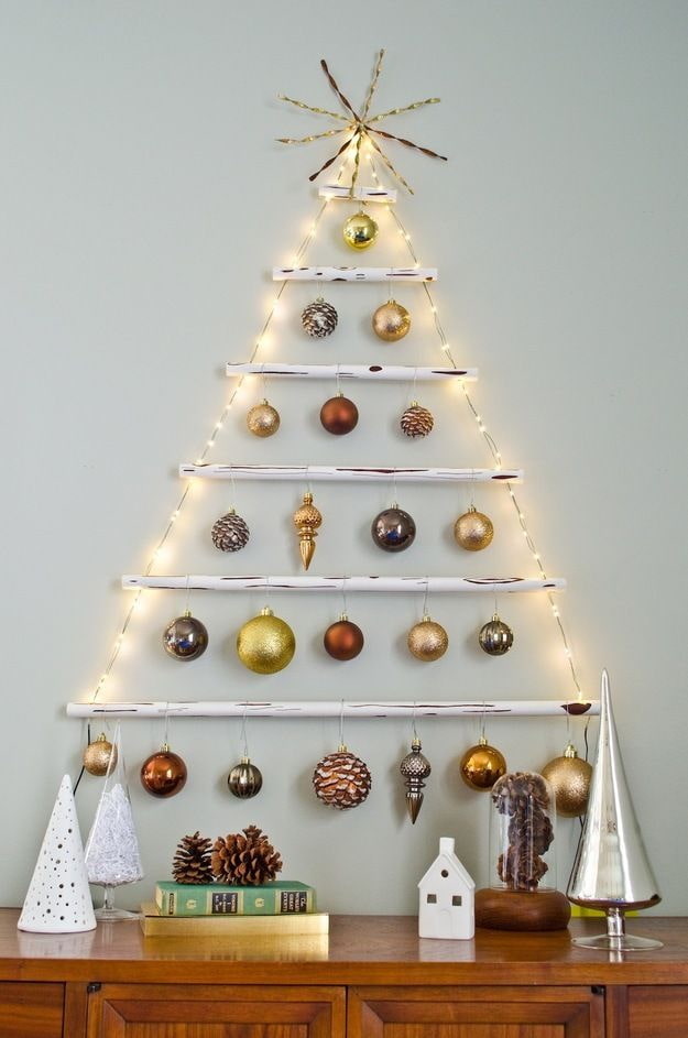 Árbol de Navidad hecho de palitos, bolas y guirnalda