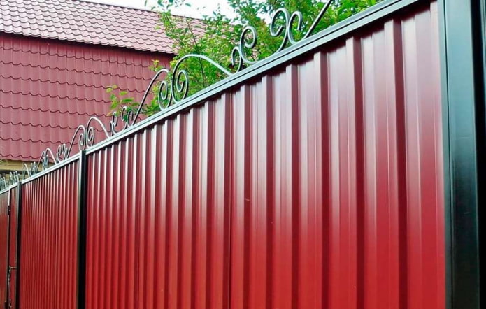 Valla roja de chapa perfilada con elementos forjados