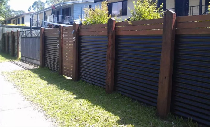 Valla de chapa ondulada con postes de madera