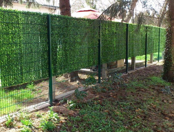 agujas de pino artificiales en una cerca de alambre