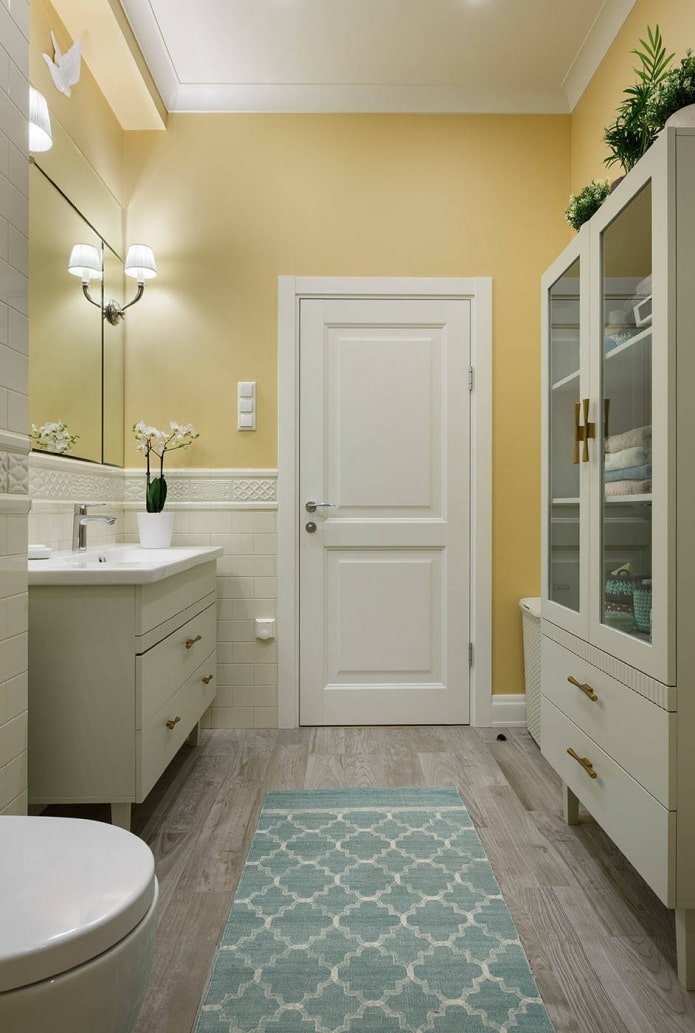 baño con paredes amarillo pálido y muebles blancos