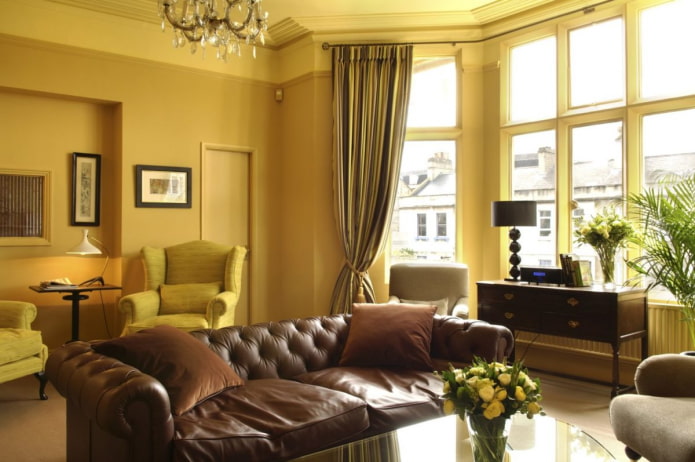 salón amarillo oscuro con sofá de cuero marrón